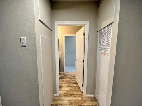 A hallway with wood floors and a white door.