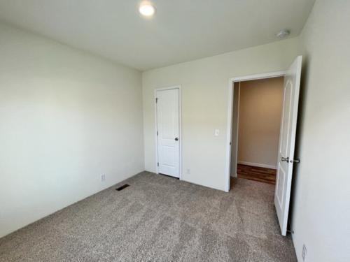 An empty room with carpet and a door.