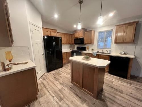 A kitchen with wood cabinets and hardwood floors.