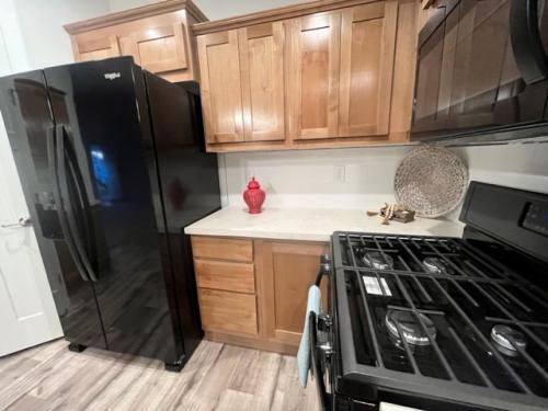 A kitchen with black appliances and wood cabinets.