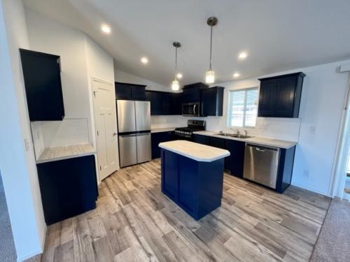 A kitchen with blue cabinets and hardwood floors.